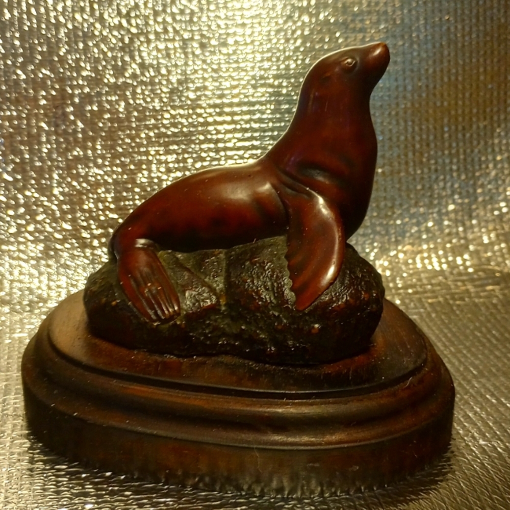 A composite seal sculpture with a rosewood  patina by native Boma Canadians